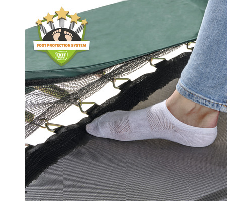 Vue détaillée d''un trampoline avec système de protection des pieds et d''une personne portant une chaussette sur la toile de saut.
