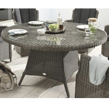 Table de jardin ronde avec plateau en verre et tressage en rotin, entourée de chaises