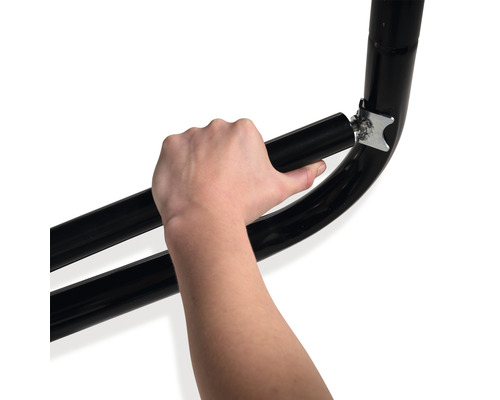 Detailansicht einer Hand, die ein schwarzes Metallrohr an einer Halterung befestigt