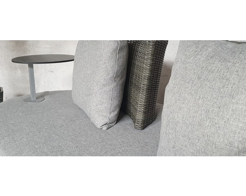 Nahaufnahme eines Lounge-Sets mit grauen Kissen und einem kleinen Tisch