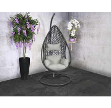 Mise en scène avec un fauteuil suspendu en forme de panier avec coussins, une glycine en pot et une orchidée suspendue