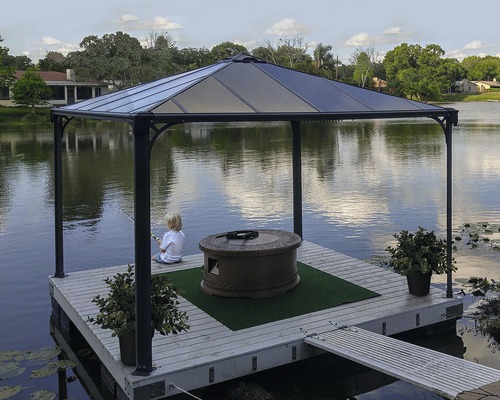 Pavillon sur un ponton avec foyer, décoration et enfant pêchant au bord du lac