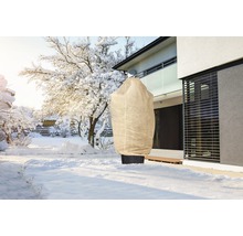 Paysage hivernal avec sac de protection des plantes dans le jardin