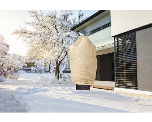 Paysage hivernal avec sac de protection des plantes dans le jardin