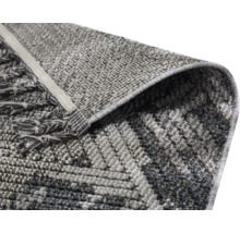 Vue détaillée d''un tapis à motif géométrique avec des franges