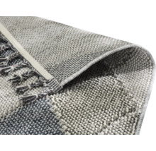 Gros plan d''un tapis tissé avec des franges