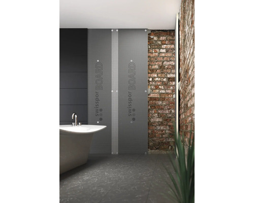 Salle de bains avec baignoire, mur de briques et deux plaques Swissport Board grises