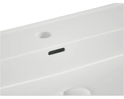 Detailansicht eines Waschbeckens mit Überlauf und Hahnloch