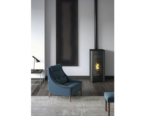 Wohnzimmer mit Sessel, Kaminofen und Wandbild