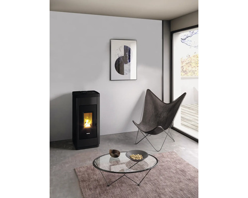 Wohnzimmer mit Pelletofen, Sessel, Couchtisch und Teppich