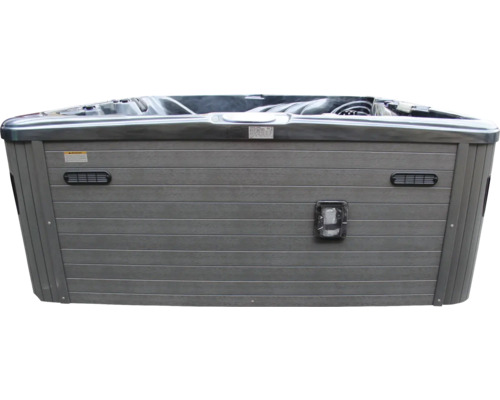 Vue extérieure d''un bain à remous avec revêtement en bois gris et couverture.