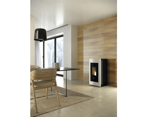 Wohnraum mit Esstisch, Stühlen und Pelletofen an der Wand