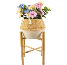 Dekorative Kunstblumen in einem Korb auf einem Bambusständer
