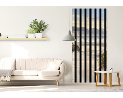 Salon avec canapé, étagère murale avec plantes et panneaux muraux décoratifs avec motif de plage