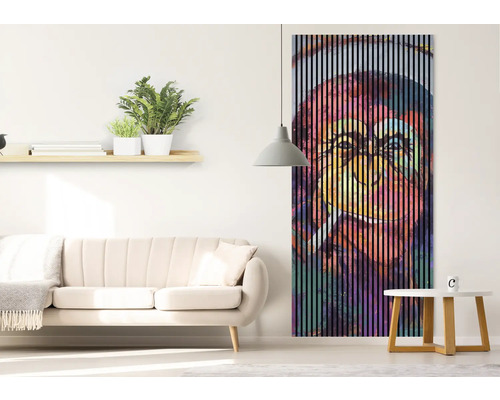 Salon avec canapé, table et tableau mural avec des rayures verticales et un motif de singe