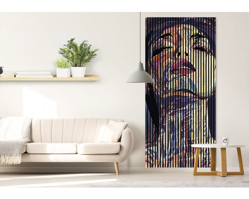 Salon avec canapé, table d''appoint, étagère et une peinture murale verticale représentant un visage de femme