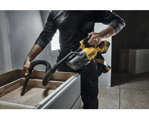 Un homme utilise un aspirateur à main DeWalt pour nettoyer un placard.