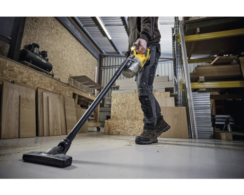 Un homme utilise un aspirateur sans fil DeWalt dans un atelier.