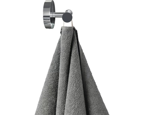 Graues Handtuch hängt an einem Handtuchhaken
