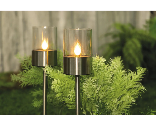 Zwei Solarleuchten mit Glaseinsatz und Erdspieß im Garten.