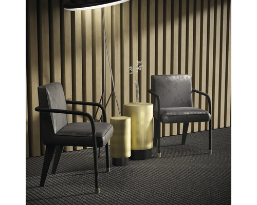 Deux fauteuils gris avec tables d''appoint et lampadaire devant un mur avec des panneaux de bois.
