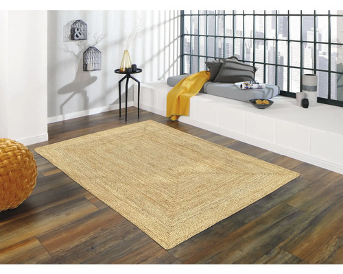 Intérieur avec tapis sur plancher en bois devant une baie vitrée