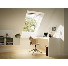 Ein Dachzimmer mit einem Schreibtisch, einem Stuhl und einem Dachfenster.