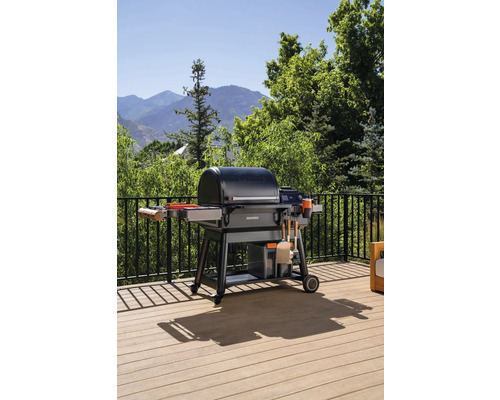 Barbecue sur une terrasse avec rambarde devant un paysage montagneux