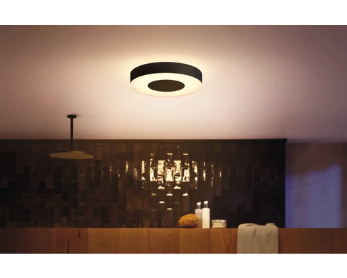 Scène de salle de bain moderne avec plafonnier circulaire, douche et étagère de rangement