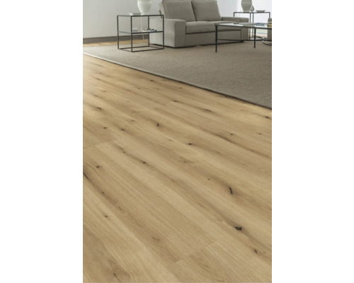 Revêtement de sol en bois dans un salon avec tapis et meubles.