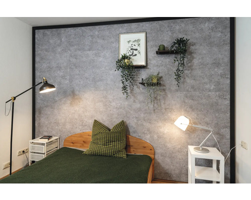 Schlafzimmer mit Wandpaneelen in Betonoptik, dekoriert mit einer Panda-Zeichnung und Pflanzen