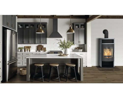 Cuisine claire avec îlot de cuisine, armoires de cuisine, hotte aspirante, réfrigérateur côte à côte et poêle à bois.