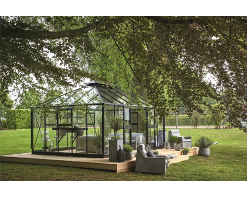 Serre avec sièges sur une terrasse en bois dans un jardin.