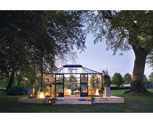 Serre avec éclairage et décoration dans le jardin