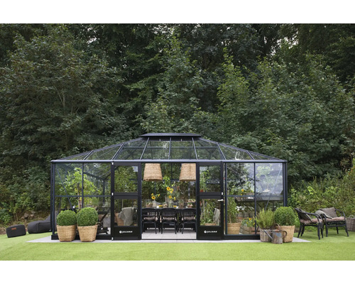 Gewächshaus mit Pflanzen und Tischgarnitur im Garten