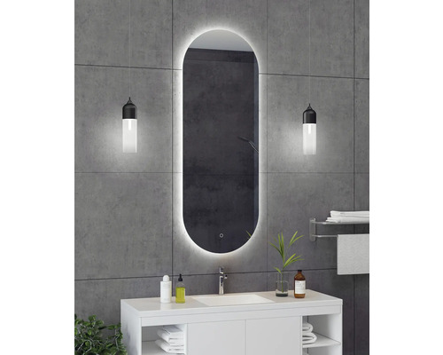 Modernes Badezimmer mit beleuchtetem Spiegel, Waschtisch und dekorativen Elementen für ein stilvolles Ambiente