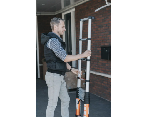 Un homme manipule une échelle télescopique.