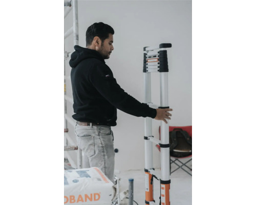 Un homme tient une échelle télescopique à l''intérieur