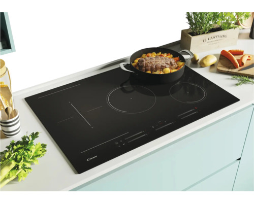 Plaque de cuisson noire avec une casserole contenant des aliments posée dessus.