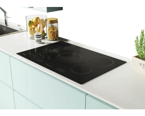 Plaque à induction noire avec quatre zones de cuisson sur un comptoir de cuisine