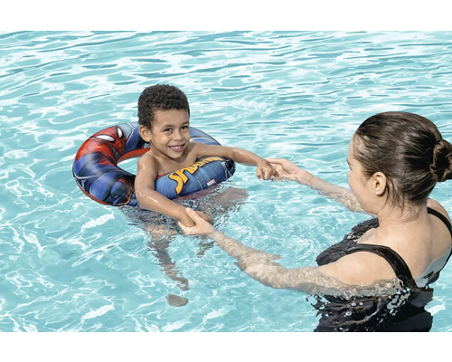 Junge mit Schwimmreifen im Pool mit Spider-Man-Motiv