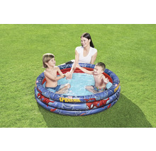 Piscine gonflable pour enfants avec motif Spiderman dans le jardin avec des enfants qui jouent et une femme.
