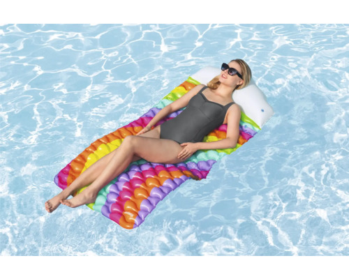 Femme se détend sur un matelas pneumatique multicolore dans l''eau