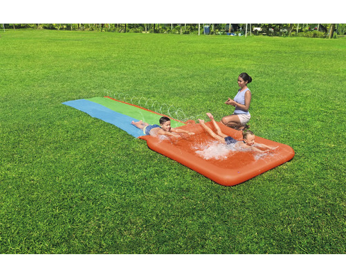 Wasserspielbahn mit Kindern auf einer Rasenfläche