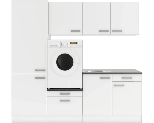 Buanderie avec machine à laver, évier et armoires en blanc
