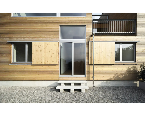 Façade d''une maison avec revêtement en bois, fenêtres et volets coulissants