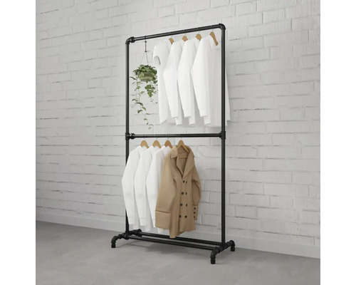 Porte-vêtements noir en tube métallique avec vêtements et plante