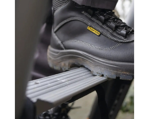 Un pied chaussé d''une chaussure de sécurité sur une marche d''une échelle.