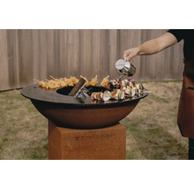 Grill TigerFire avec brochettes et personne ajoutant de l''huile