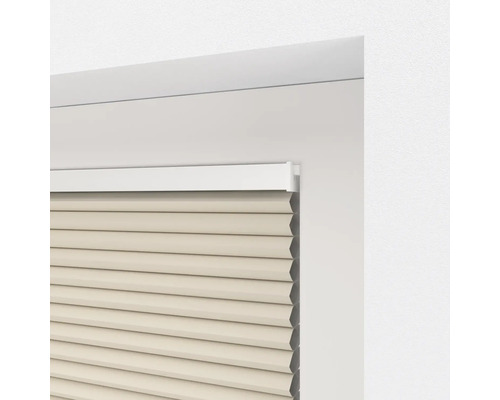 Detailansicht einer beigen Faltstore-Jalousie im Fensterrahmen.
